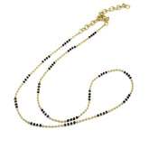 Two beaded necklaces, one gold and one black, on a white background.