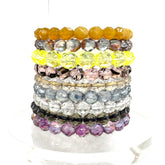 Stack of colorful beaded bracelets on a white background