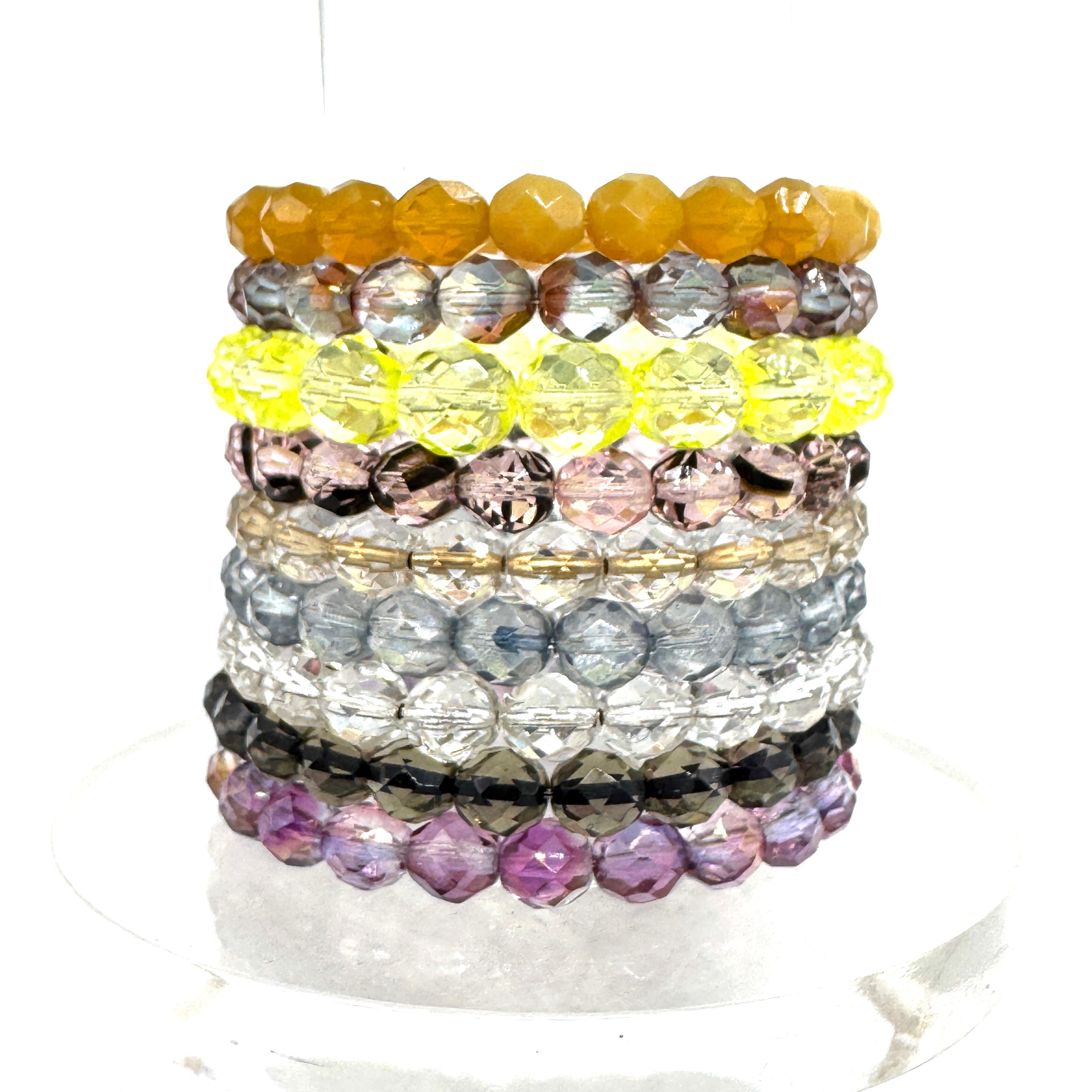 Stack of colorful beaded bracelets on a white background