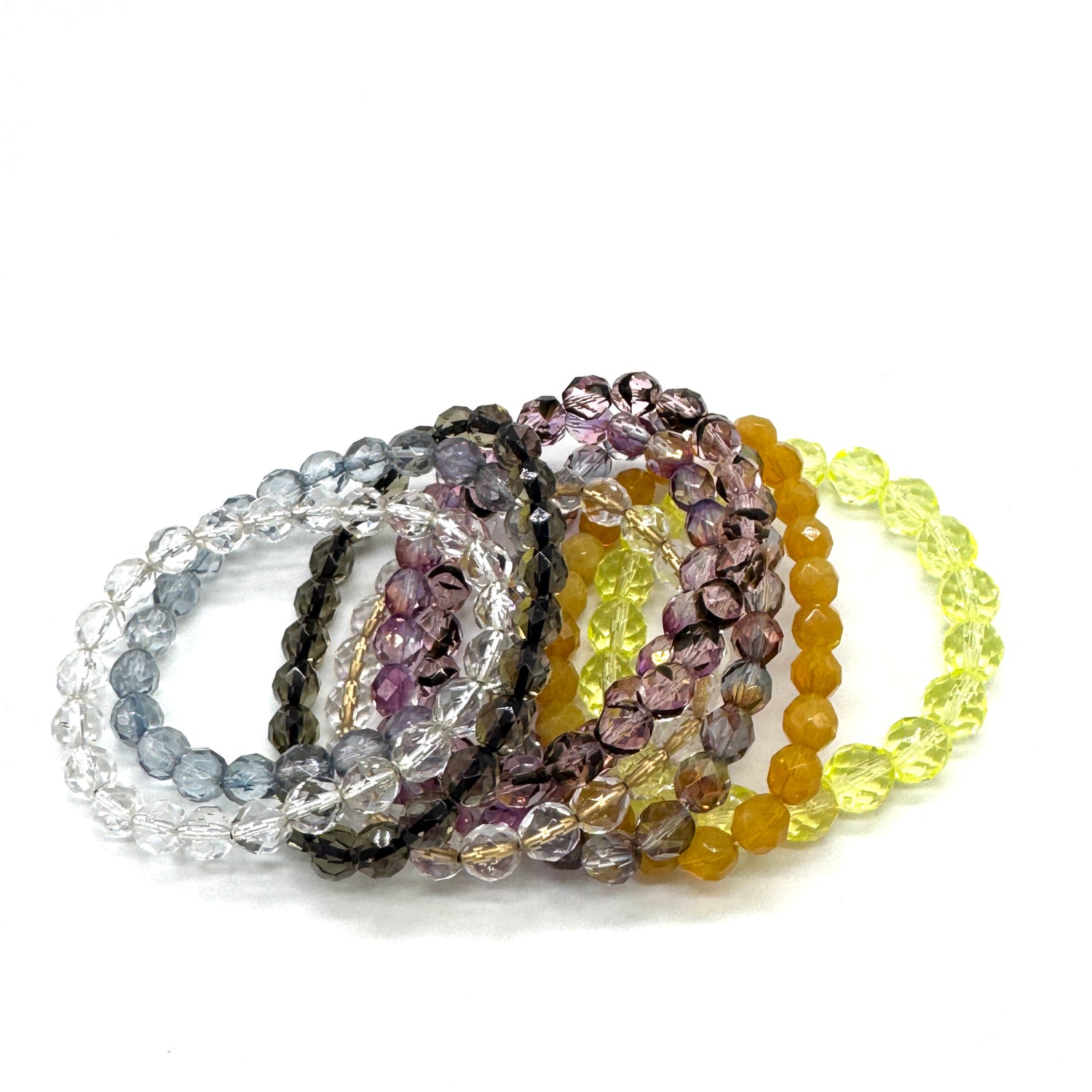 Set of beaded bracelets in various colors on a white background