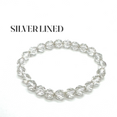 Silver beaded bracelet on a white background with &