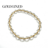 Gold-lined clear beaded bracelet on a white background