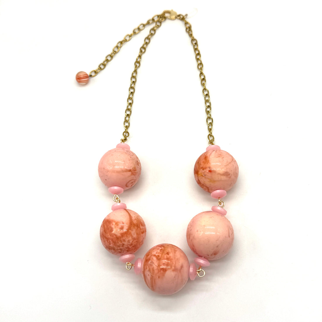 Necklace with pink and gold beads on a white background