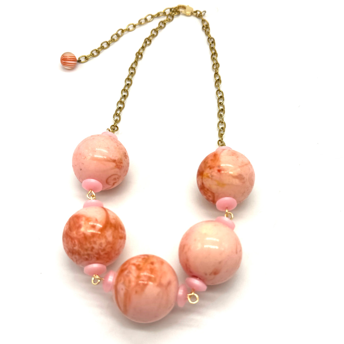 Necklace with pink and orange marbled beads on a white background