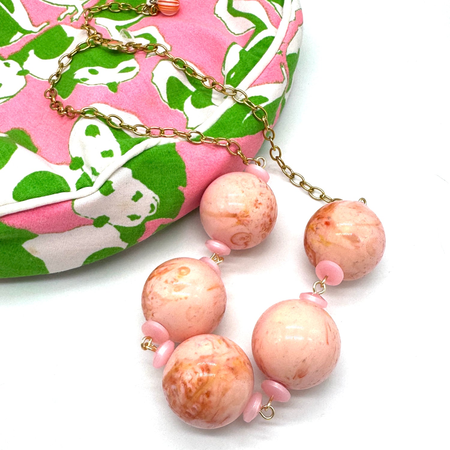 Necklace with pink and gold beads on a white background