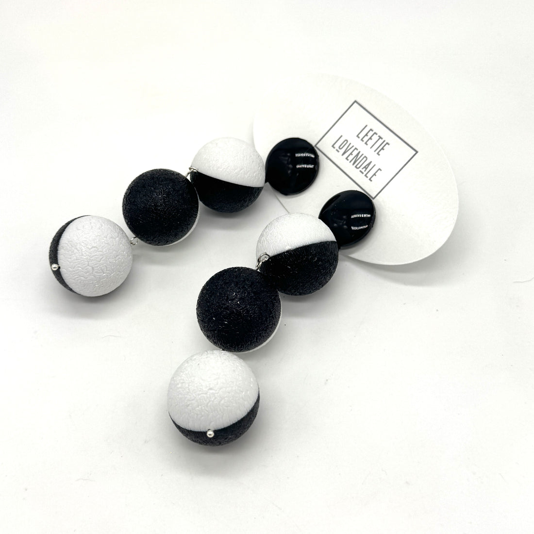 Black and white earrings on a white background with &