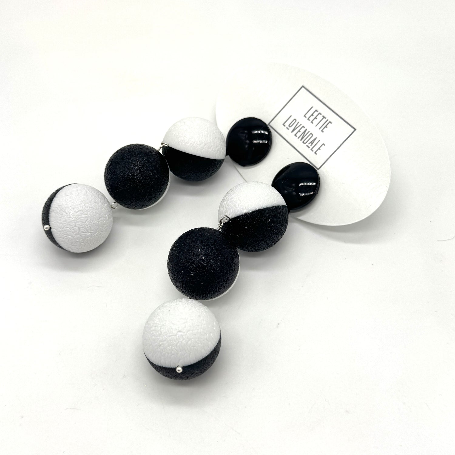 Black and white earrings on a white background with &