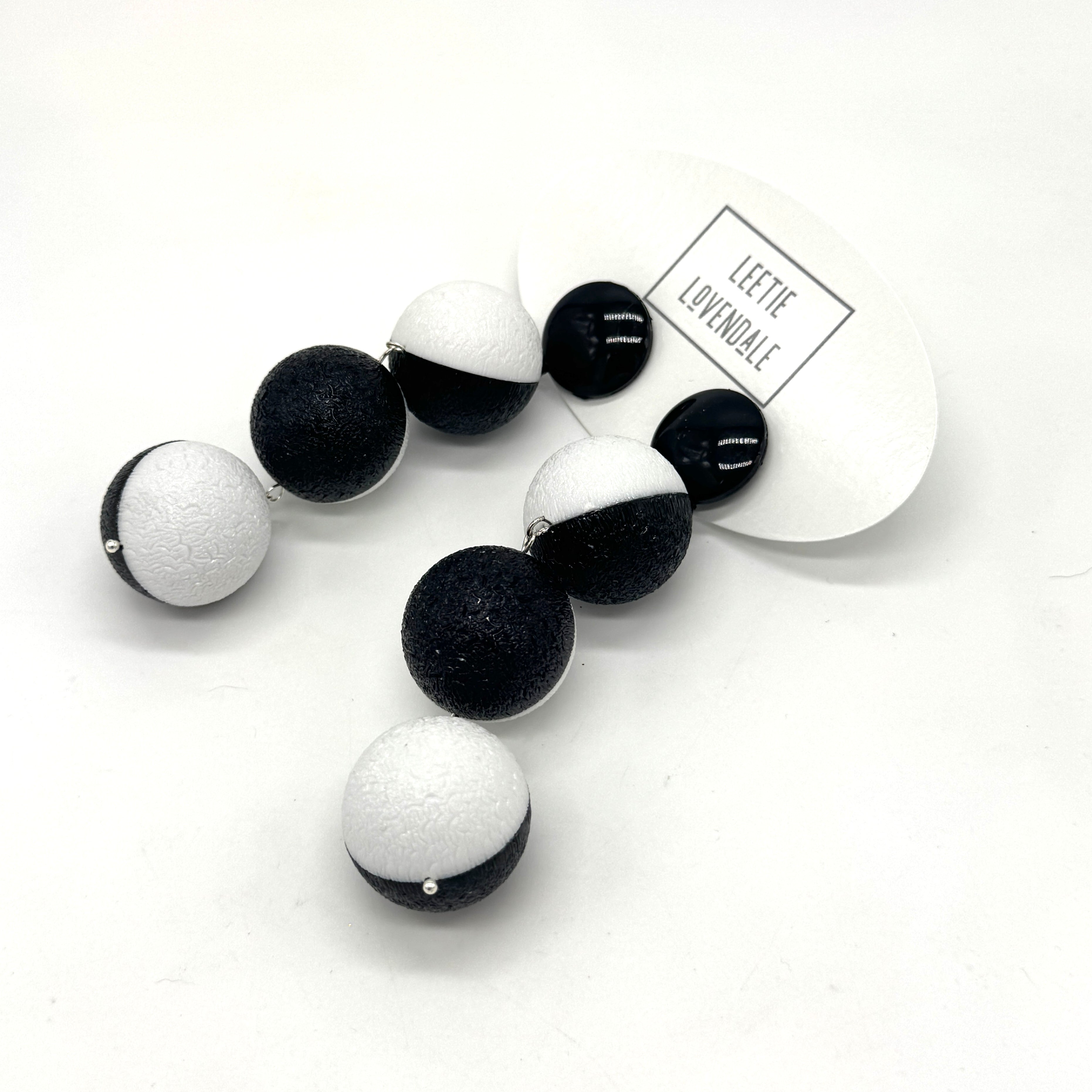 Black and white earrings on a white background with &