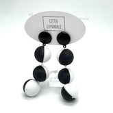 Black and white earrings on a display card with &