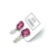 Pink crystal earrings on a white card with &