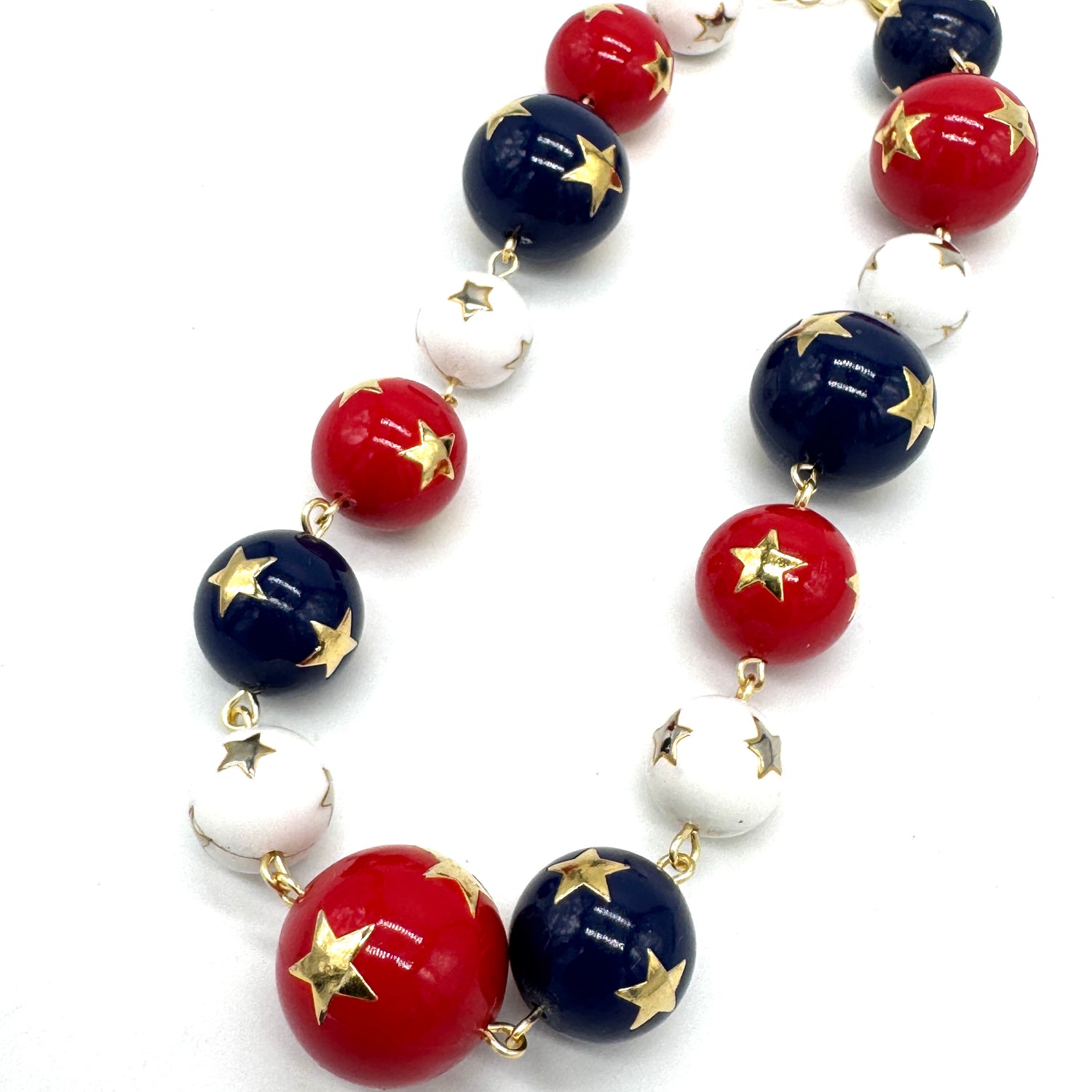 Necklace with red, white, and blue beads with gold stars on a white background