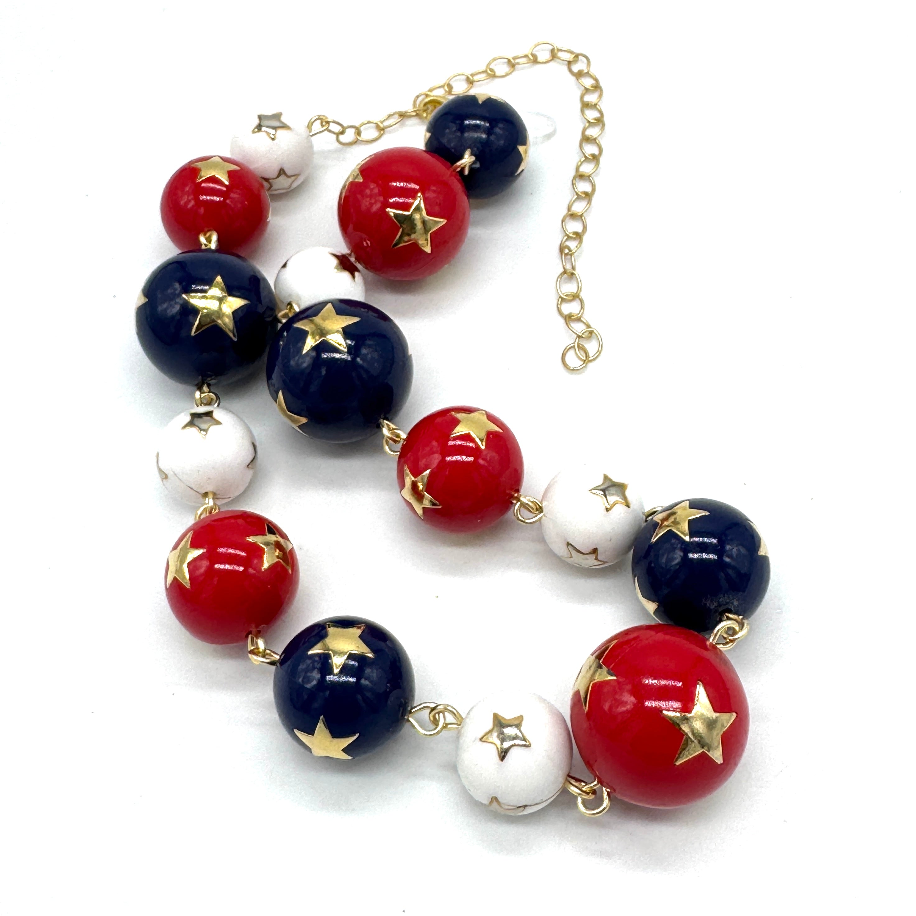Necklace with red, white, and blue beads with gold stars on a white background