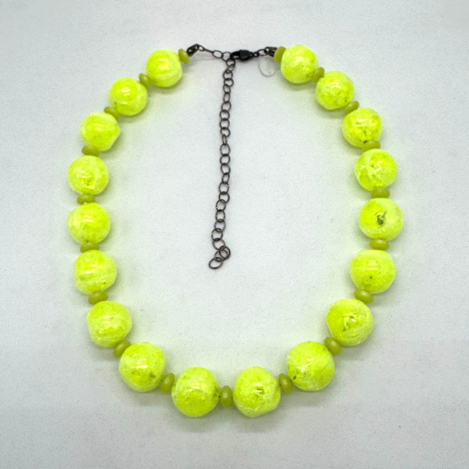 Neon yellow beaded necklace on a light gray background