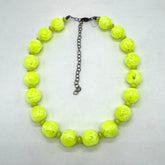 Neon yellow beaded necklace on a light gray background