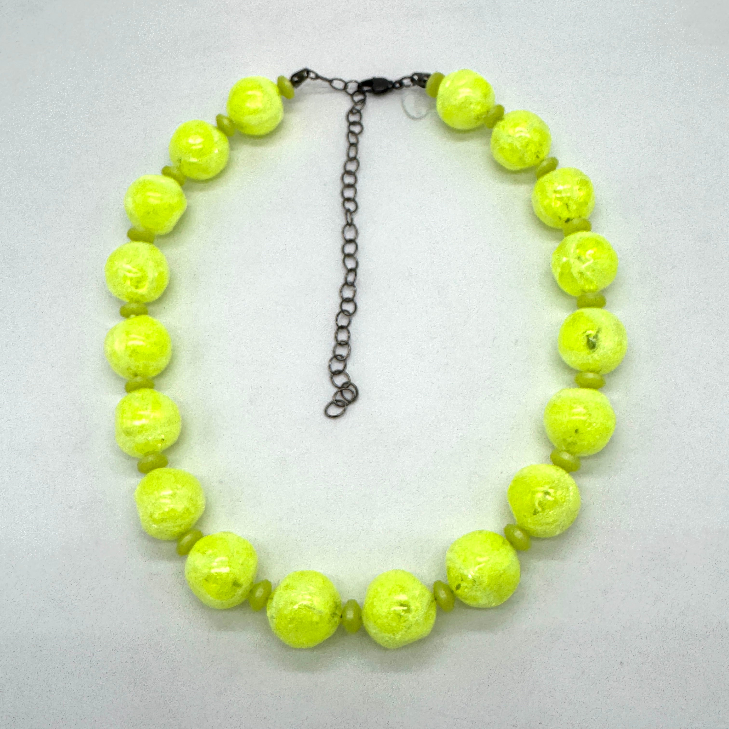 Neon yellow beaded necklace on a light gray background