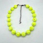 Necklace with bright yellow beads on a light gray background