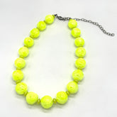 Neon yellow beaded necklace on a white background