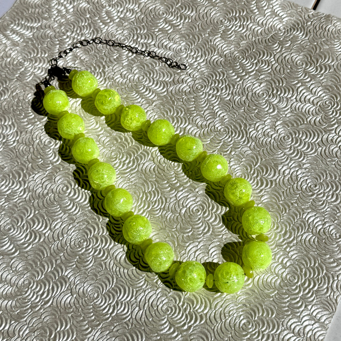 Neon yellow beaded bracelet on a textured silver surface