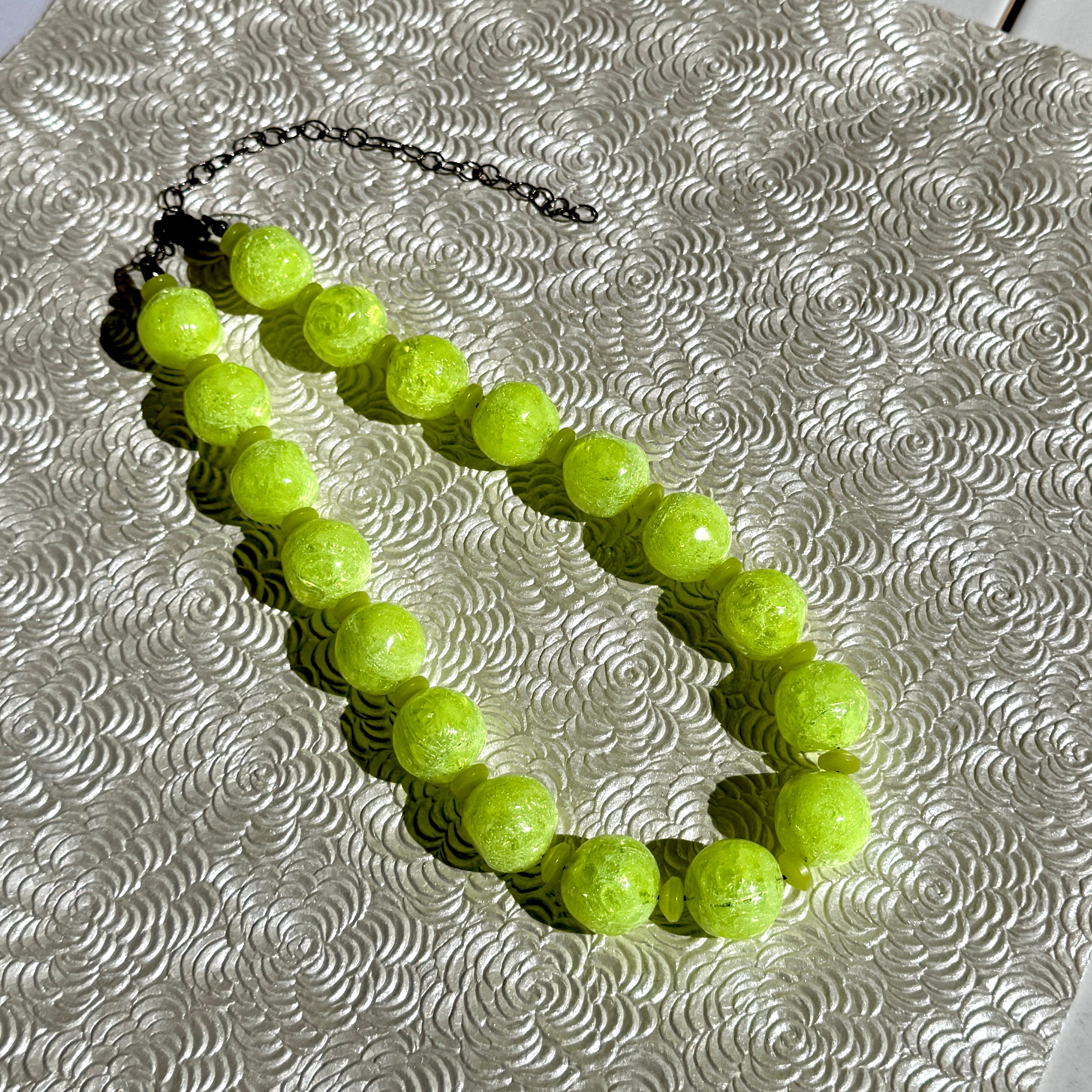 Neon yellow beaded bracelet on a textured silver surface