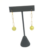 chartreuse bead and gold chain earring on a stand