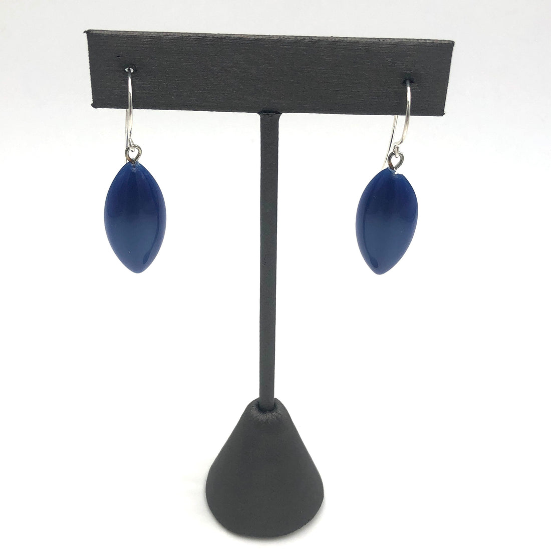 marquis shaped blue earrings on a stand
