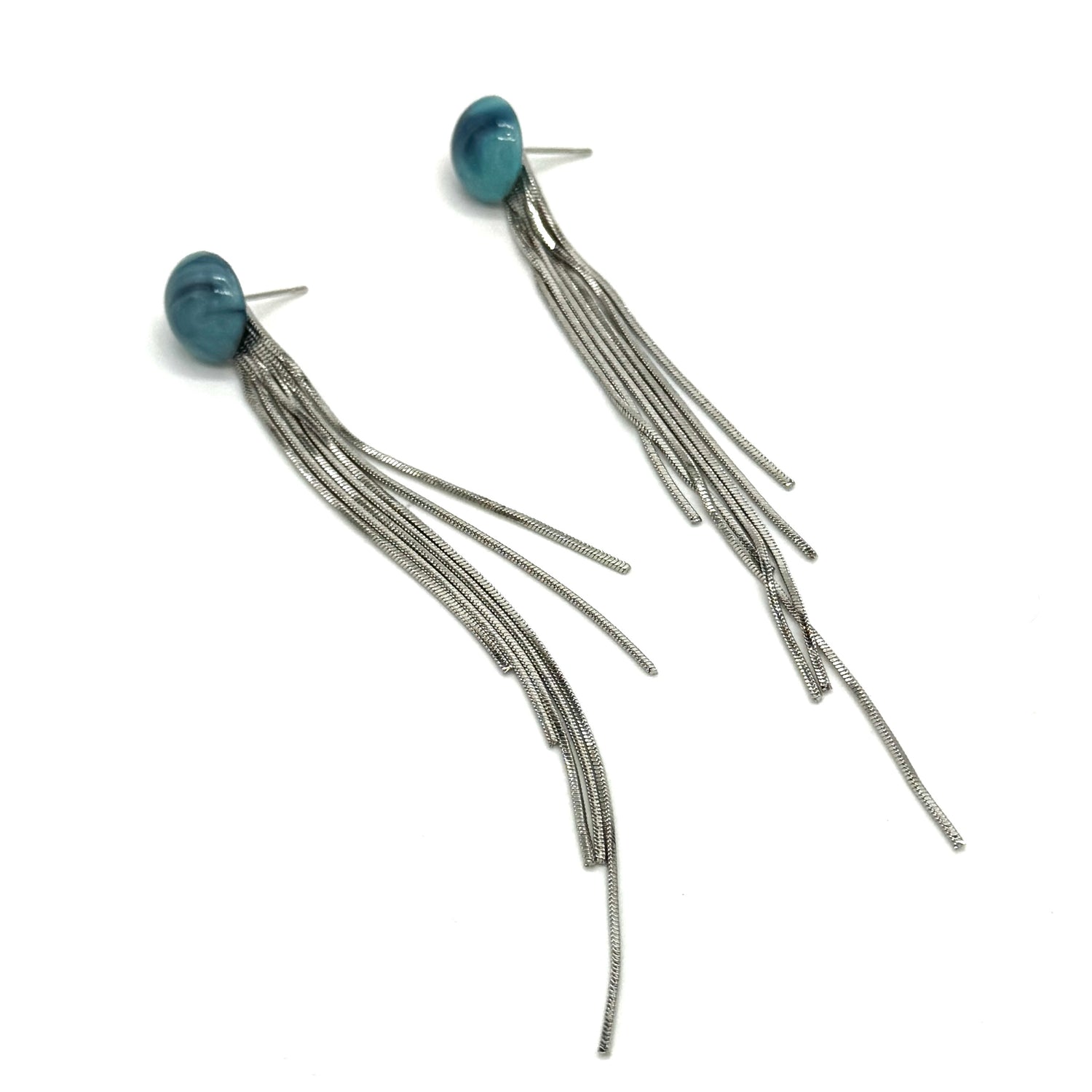 Pair of earrings with blue beads and long silver strands on a white background