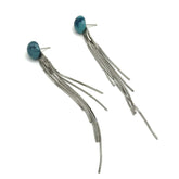 Pair of earrings with blue beads and long silver strands on a white background