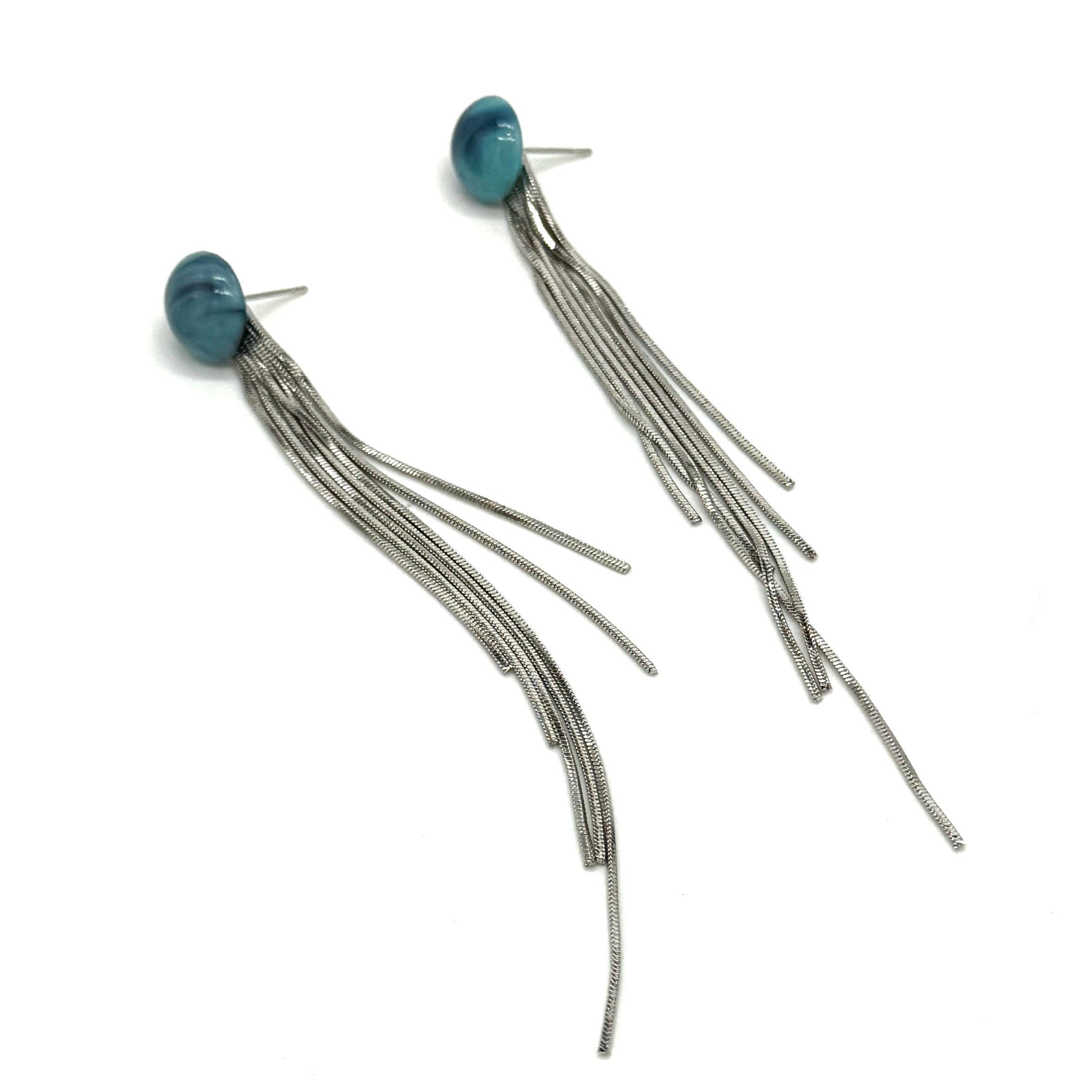 Pair of earrings with blue beads and long silver strands on a white background