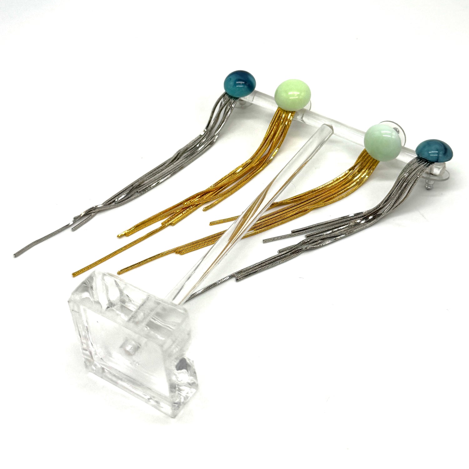 Set of fringe earrings with colorful beads on white background