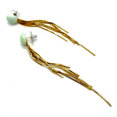 Gold tassel earrings with a light green bead on a white background