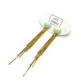 Gold fringe earrings with green beads on a white background