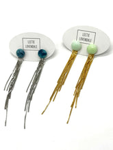 Set of fringe earrings with colorful beads on white background