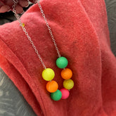 Necklace with colorful bead pendants on a pink fabric background