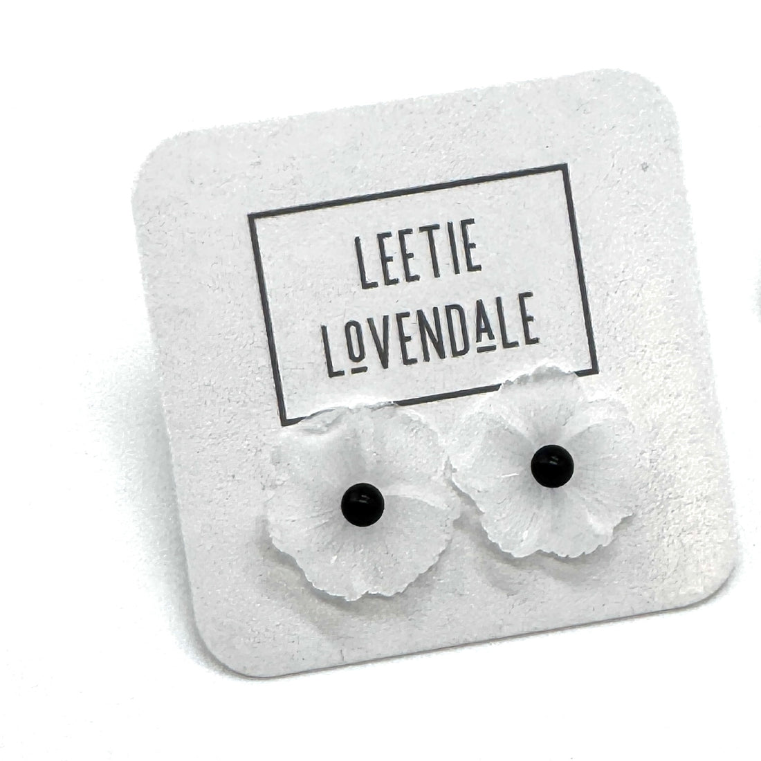 Flower-shaped earrings on a branded card with &