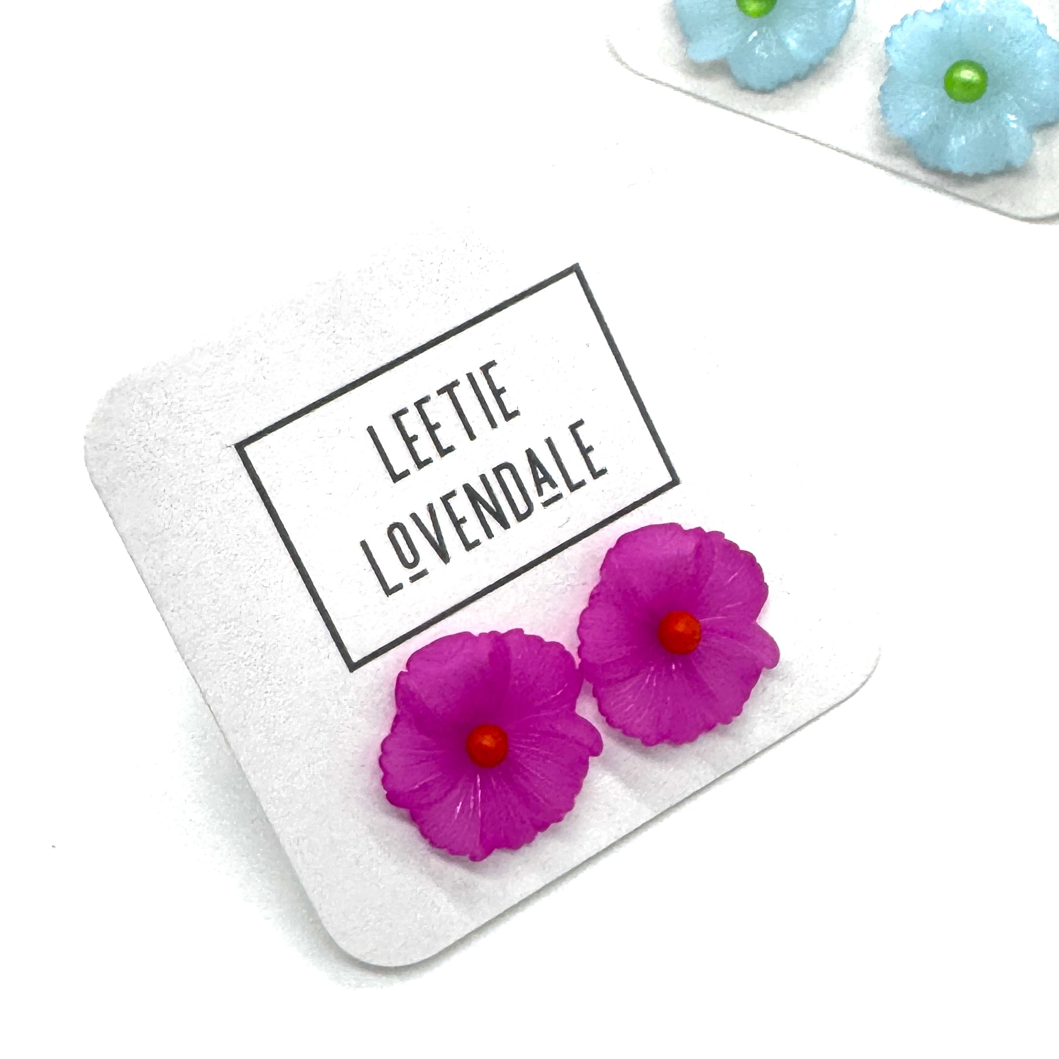 Pink flower earrings on a branded card with &