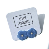 Blue flower-shaped earrings on a Leetie Lovendale branded card.