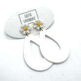 White hoop earrings with daisy flower charms on a white background