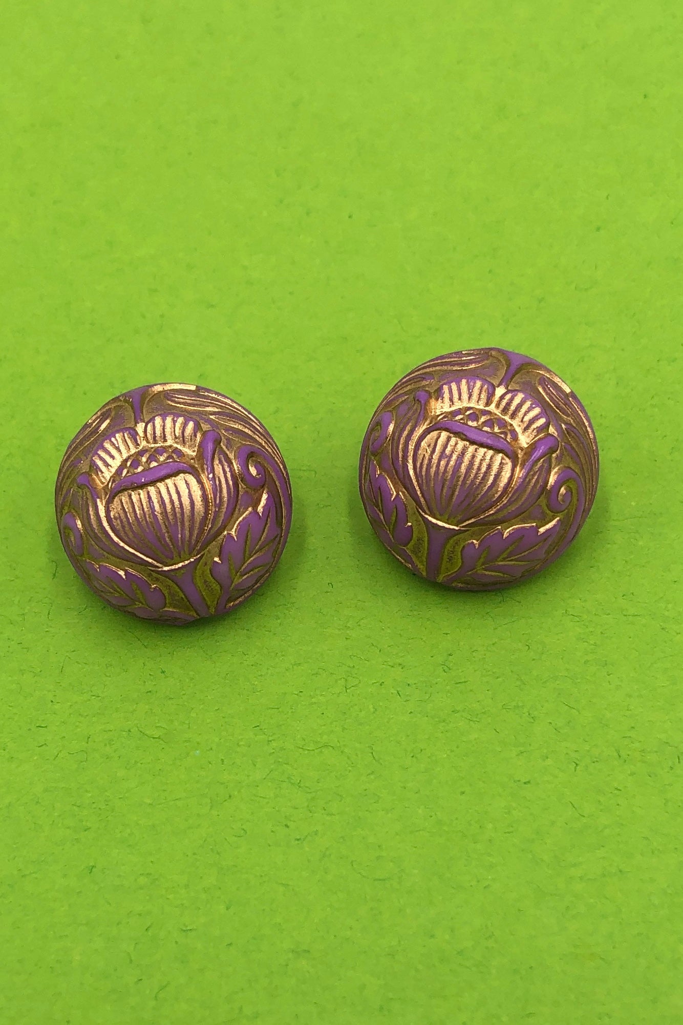 lilac and gold button stud earrings with carved tulips on green background