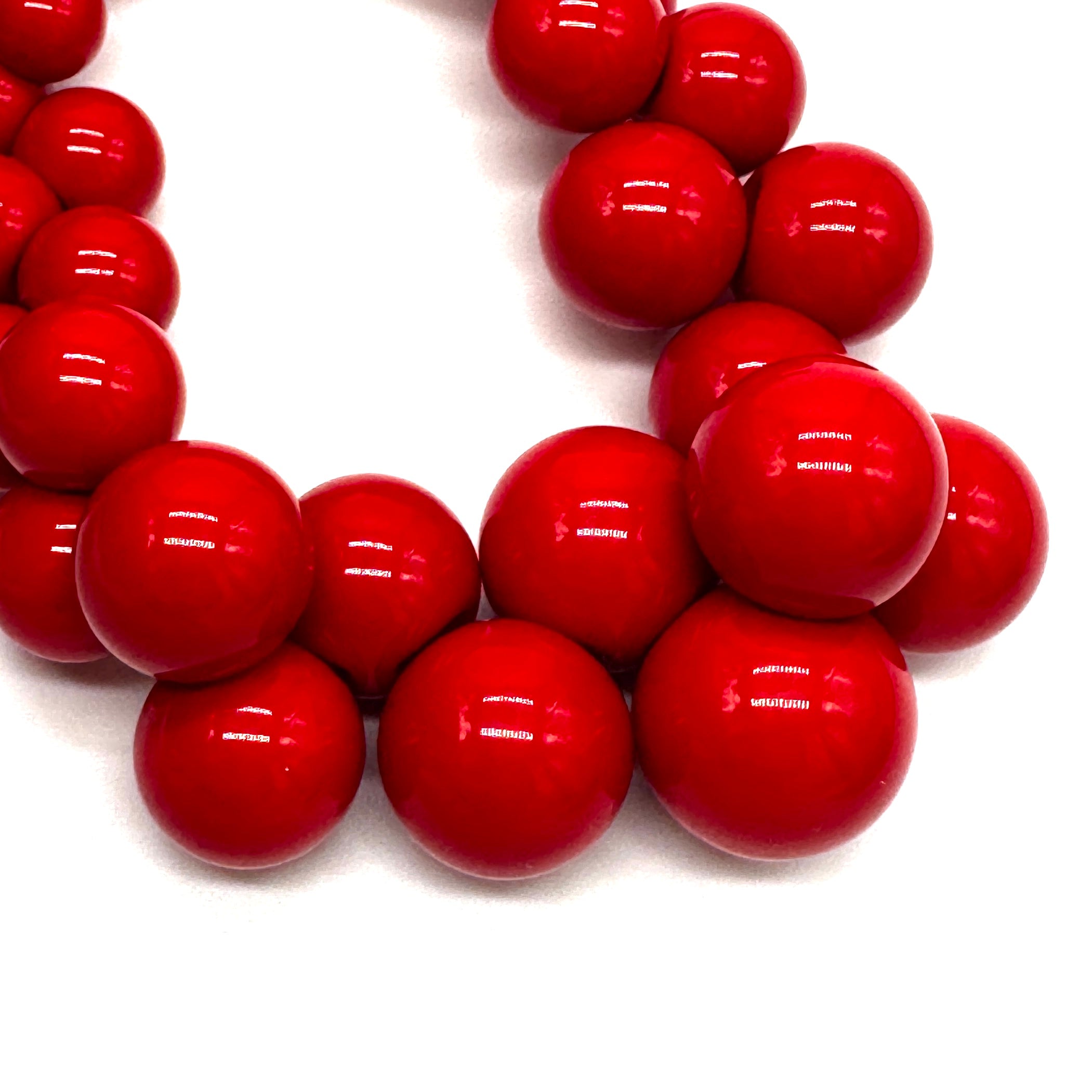 Close-up of red beads on a white background
