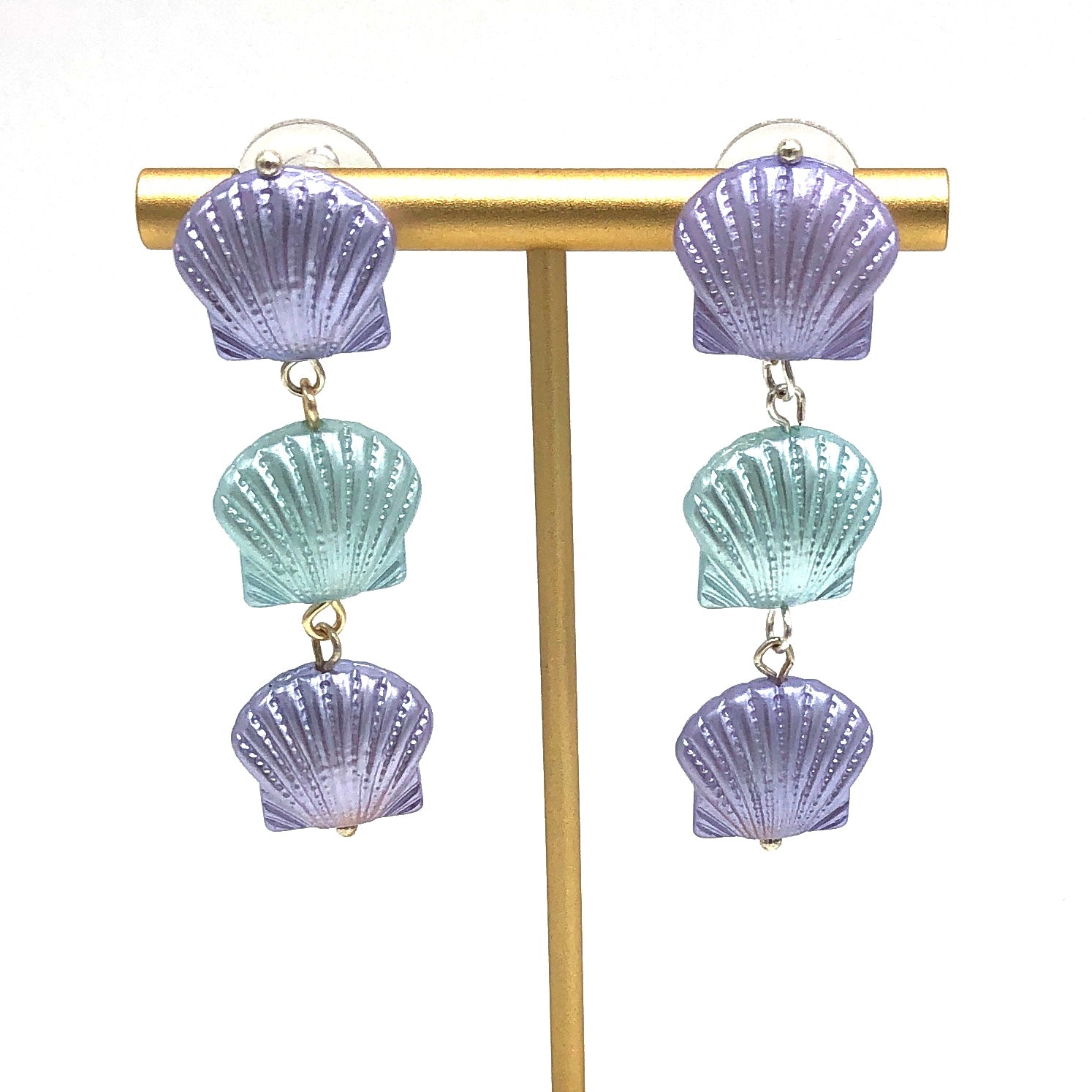 Periwinkle and ice blue seashell style earrings on a gold stand