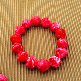 Red beaded bracelet on a textured brown background