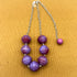 Beaded necklace with purple beads on a textured brown background
