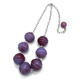 Necklace with purple beads on a white background
