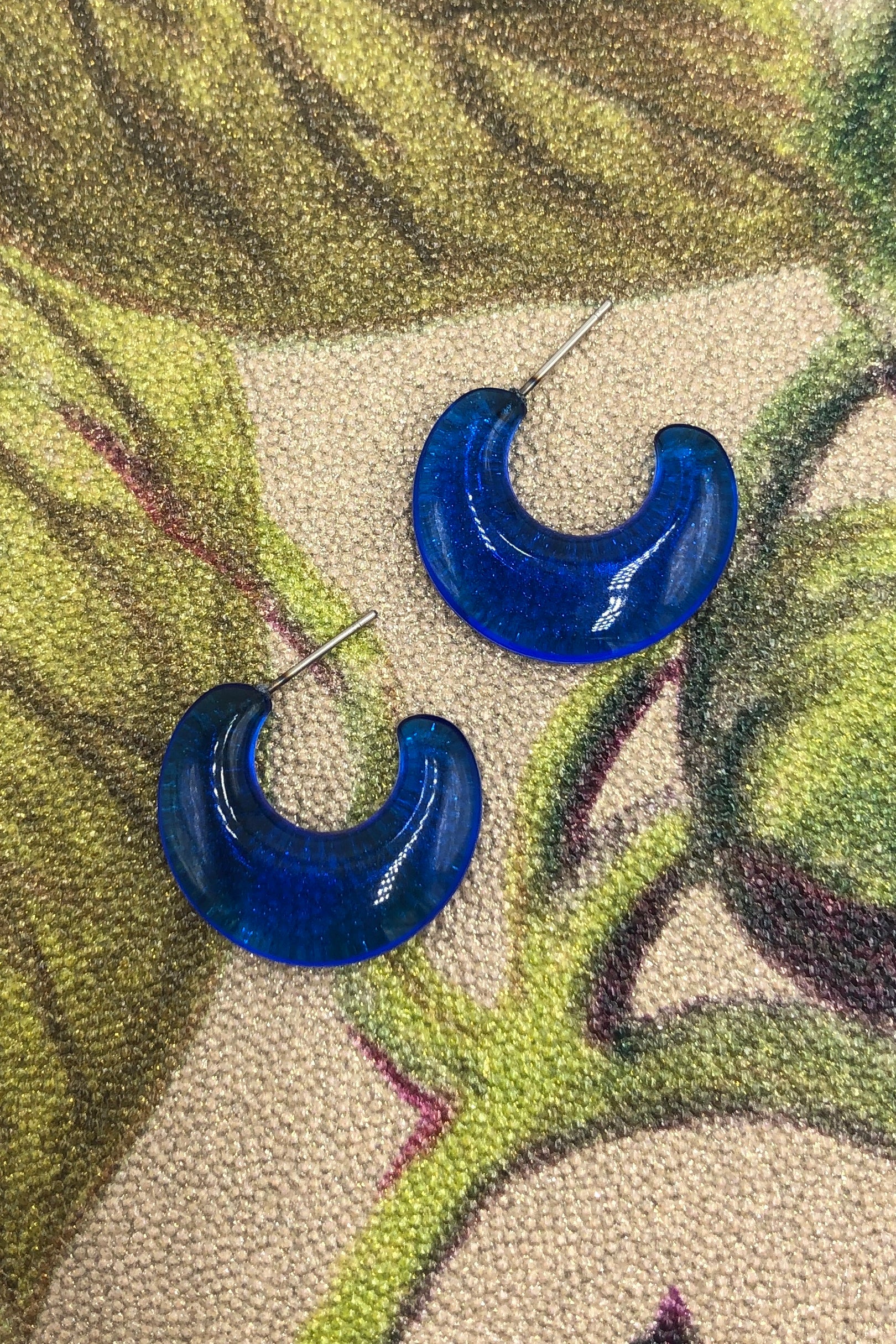 capri blue flat hoop earrings on colorful background