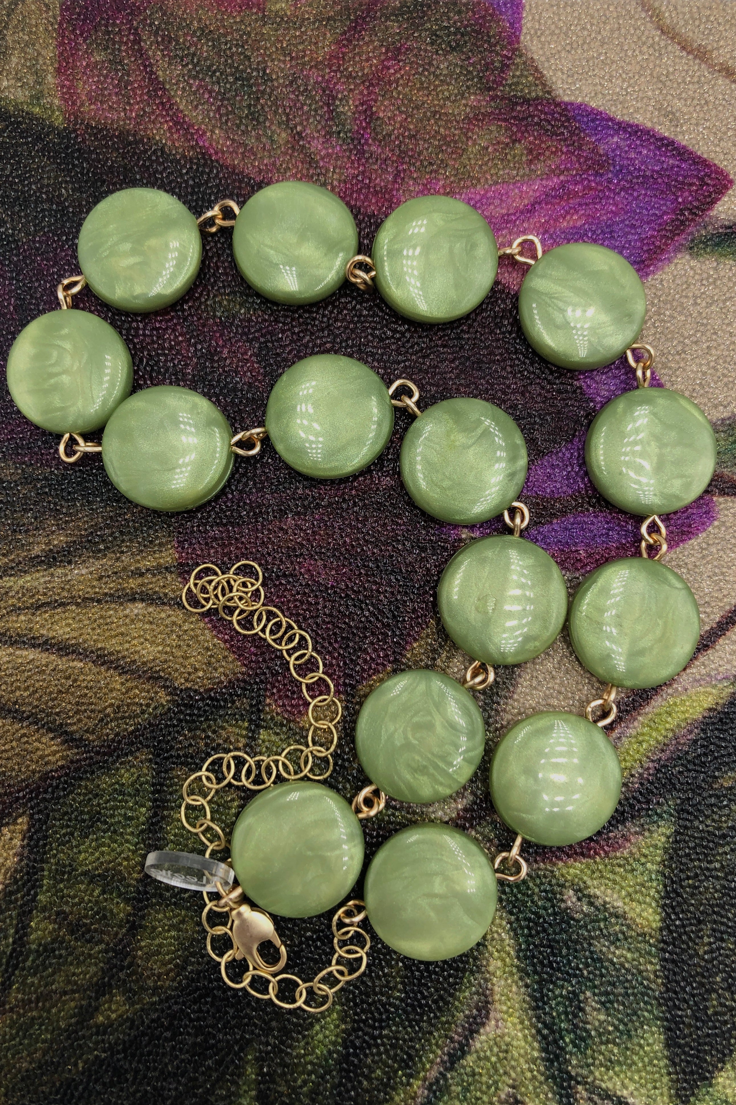 sage green hand wired necklace on colorful background 
