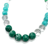Necklace with green and clear beads on a white background