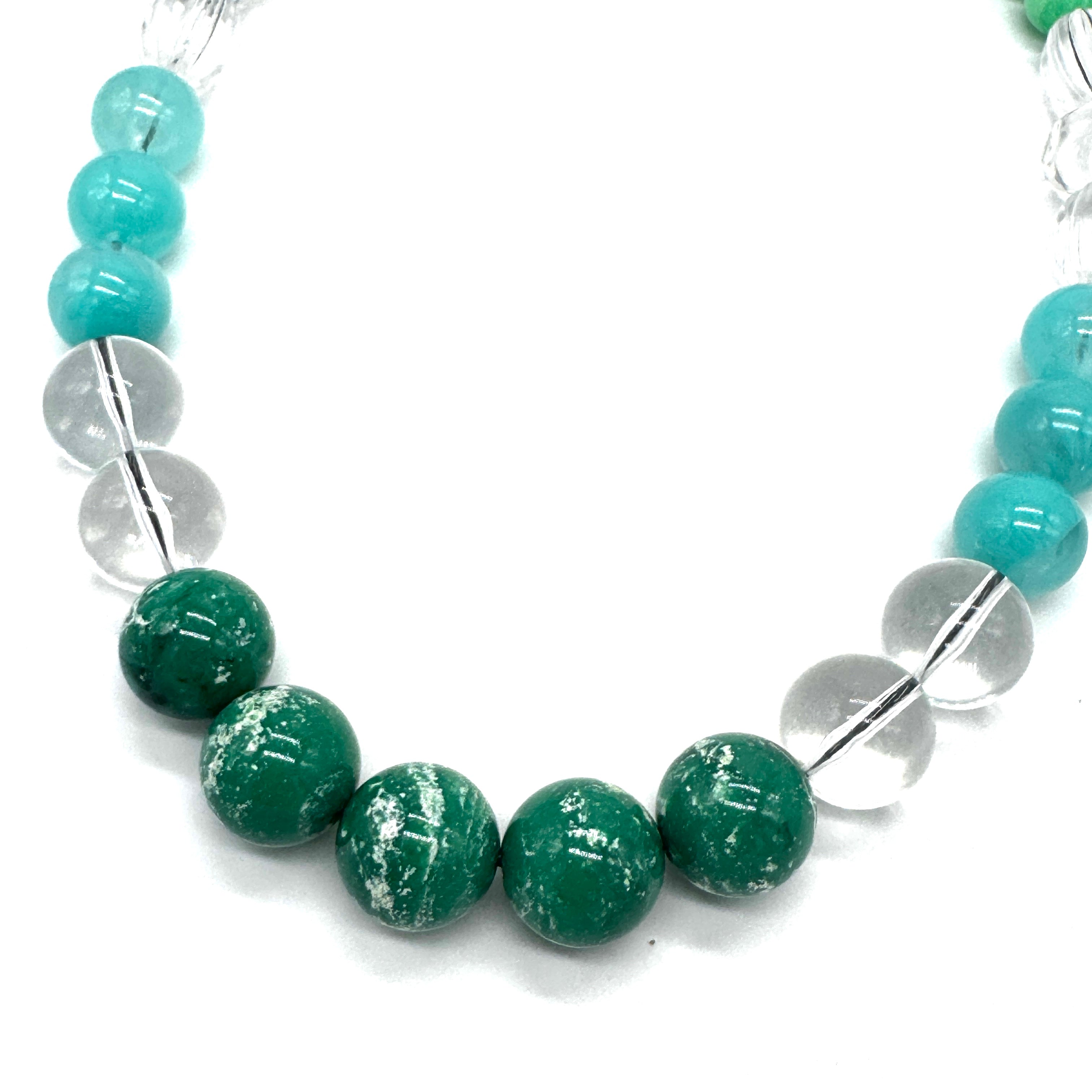 Necklace with green and clear beads on a white background