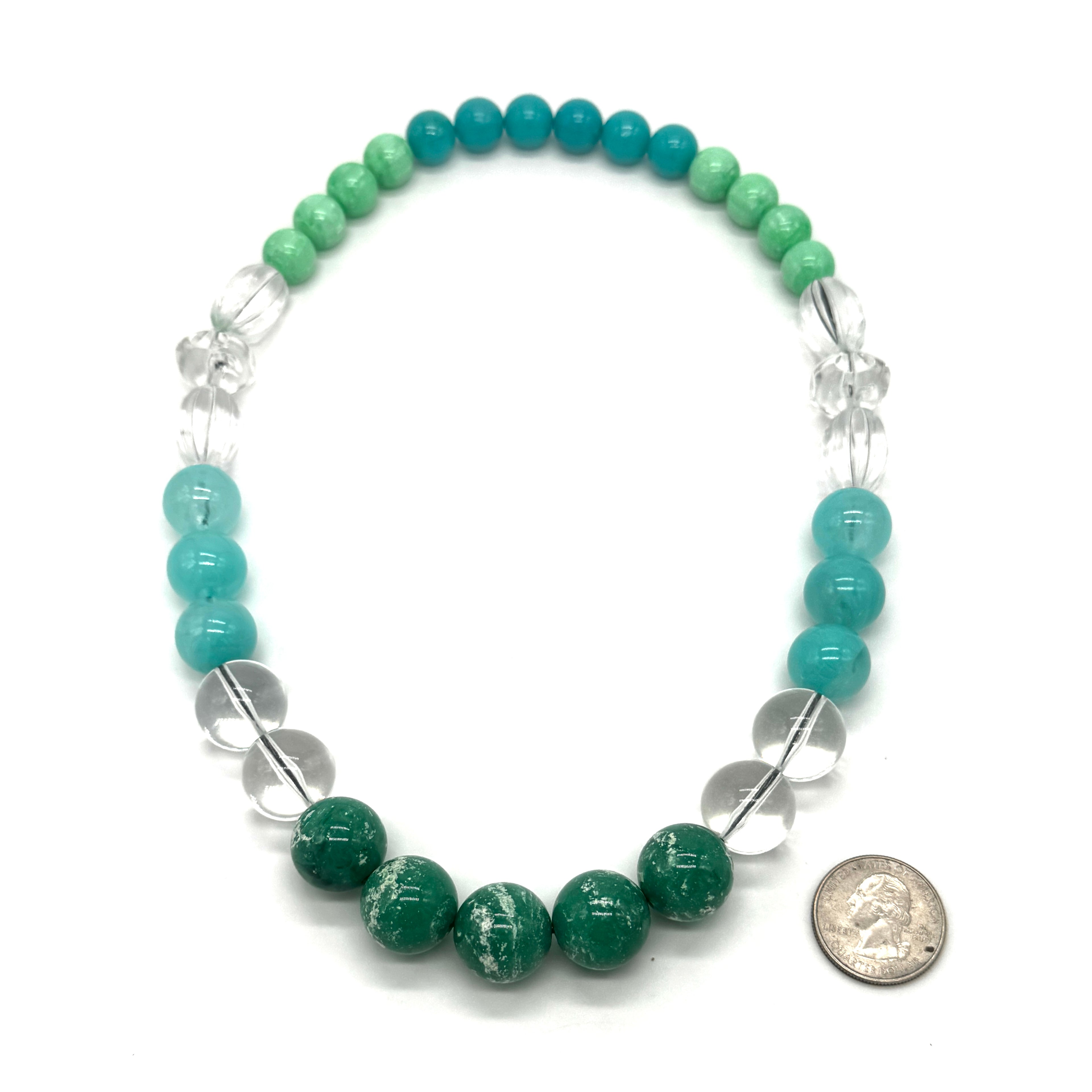 Necklace with green and blue beads and clear accents on a white background