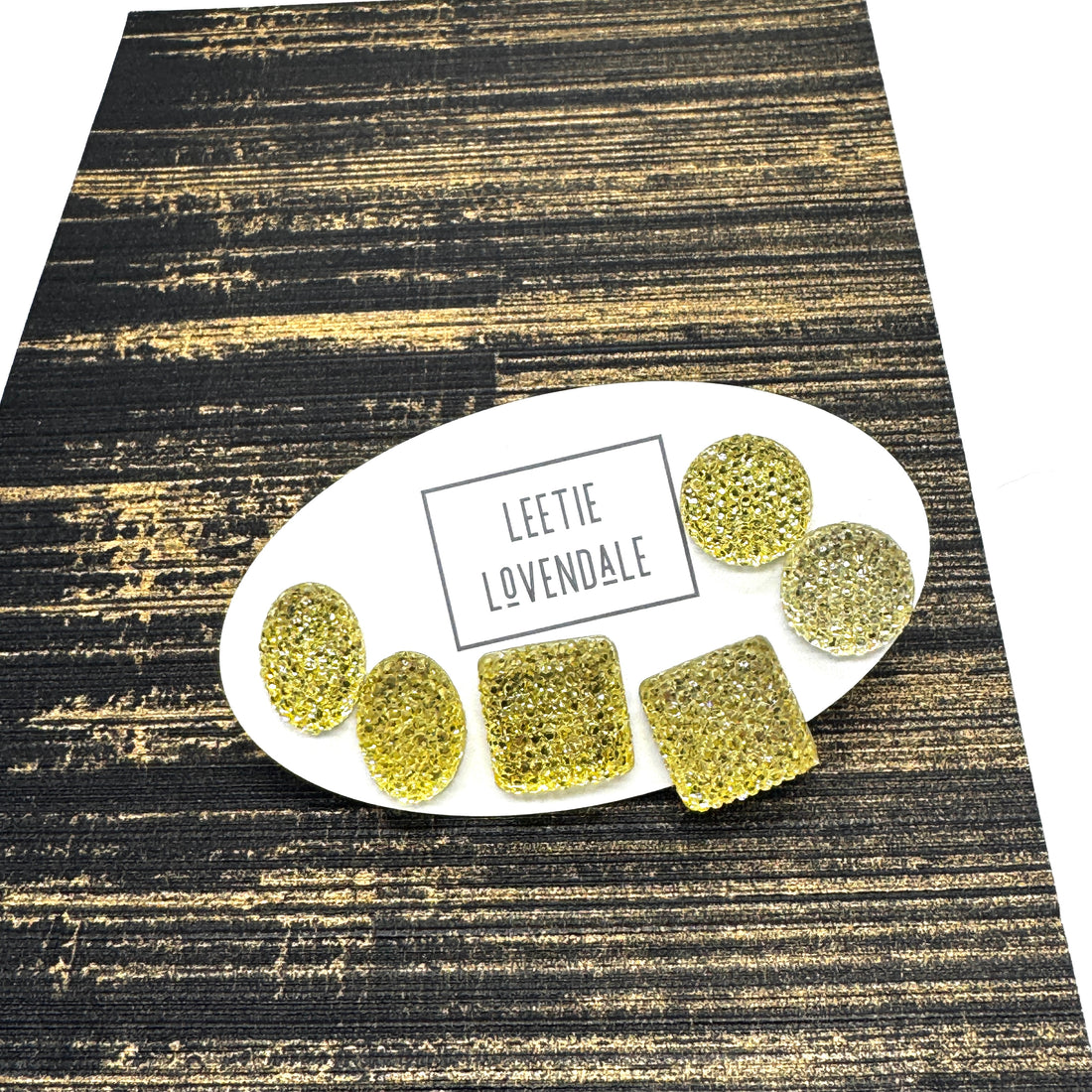 Yellow textured stud earrings on a white card with Leetie Lovendale branding on a white background.