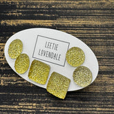 Yellow textured stud earrings on a white card with Leetie Lovendale branding on a white background.